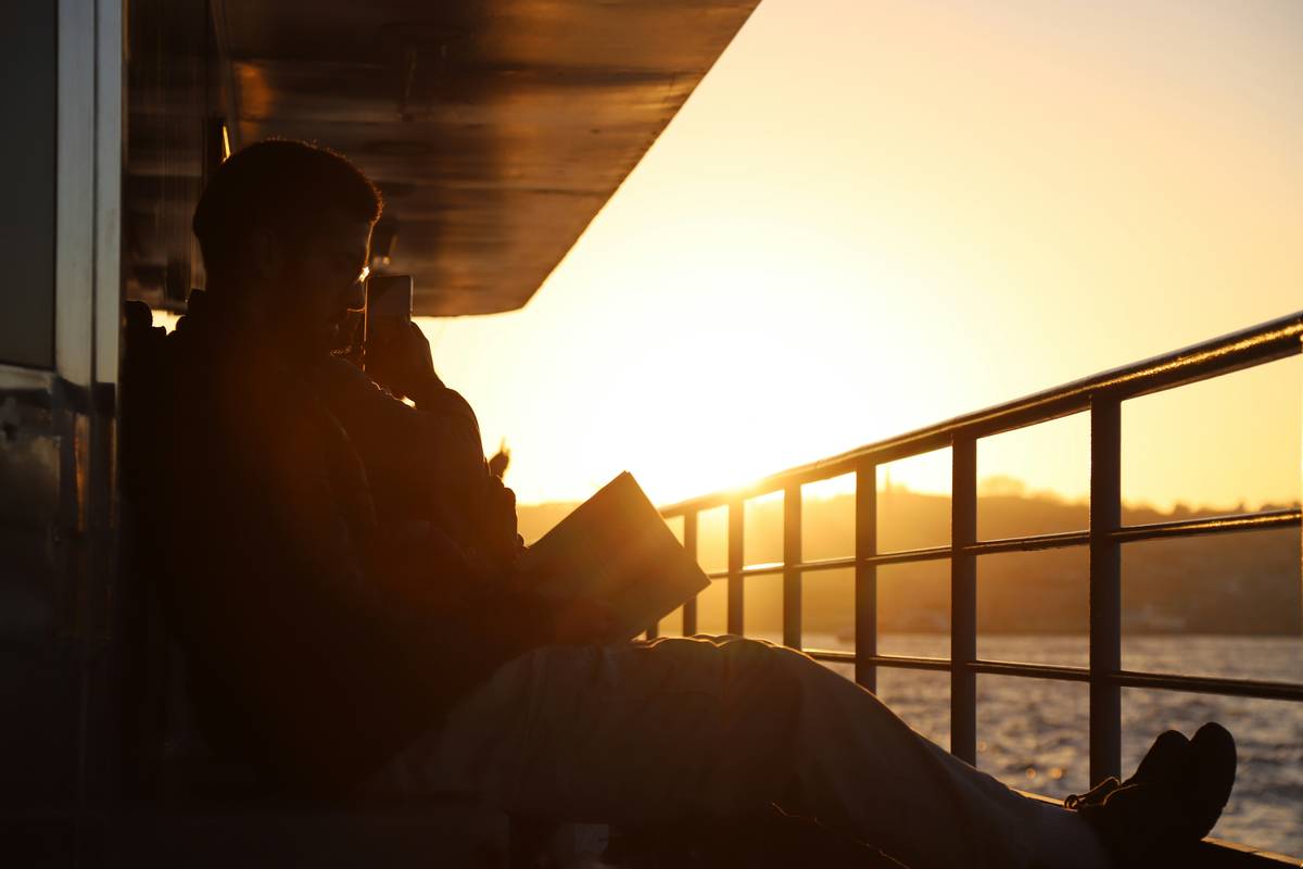 Passenger reviewing water voyage coverage documents while on a river cruise deck
